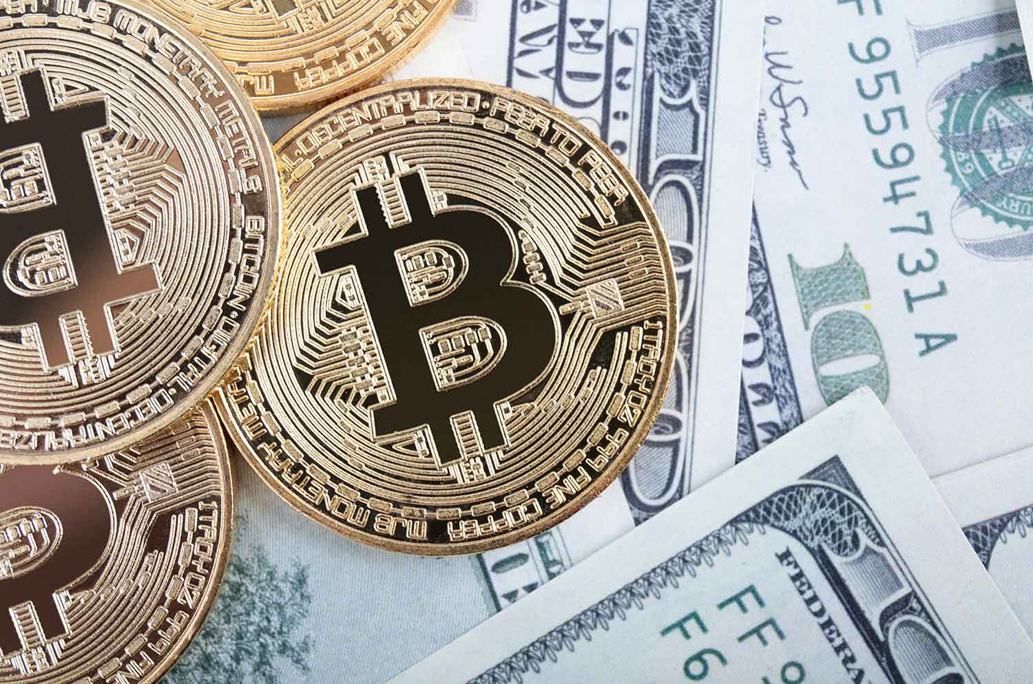 Bitcoin coins lying on US dollar notes