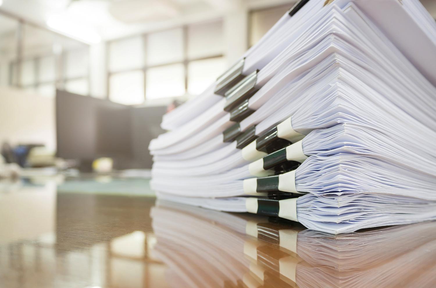 A stack of business documents on a desk